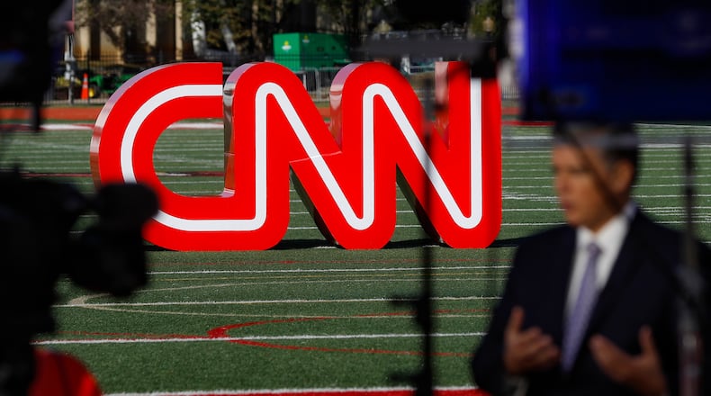 FILE - A journalist records video near a CNN sign on an athletic field outside the Clements Recreation Center where the CNN/New York Times will host the Democratic presidential primary debate at Otterbein University, Monday, Oct. 14, 2019, in Westerville, Ohio. (AP Photo/John Minchillo, File)