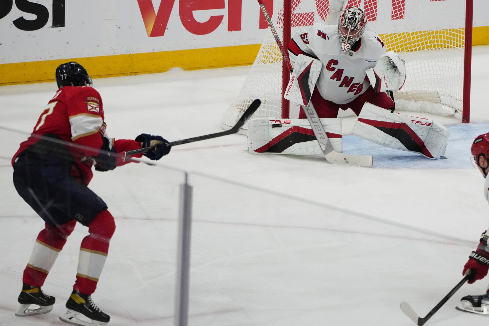 Florida Panthers defenseman Niko Mikkola, left, shoots to score a goal against Carolina Hurricanes goaltender Pyotr Kochetkov, right, during the third period in Game 3 of the NHL hockey Stanley Cup Eastern Conference finals Saturday, May 24, 2025, in Sunrise, Fla. (AP Photo/Lynne Sladky)