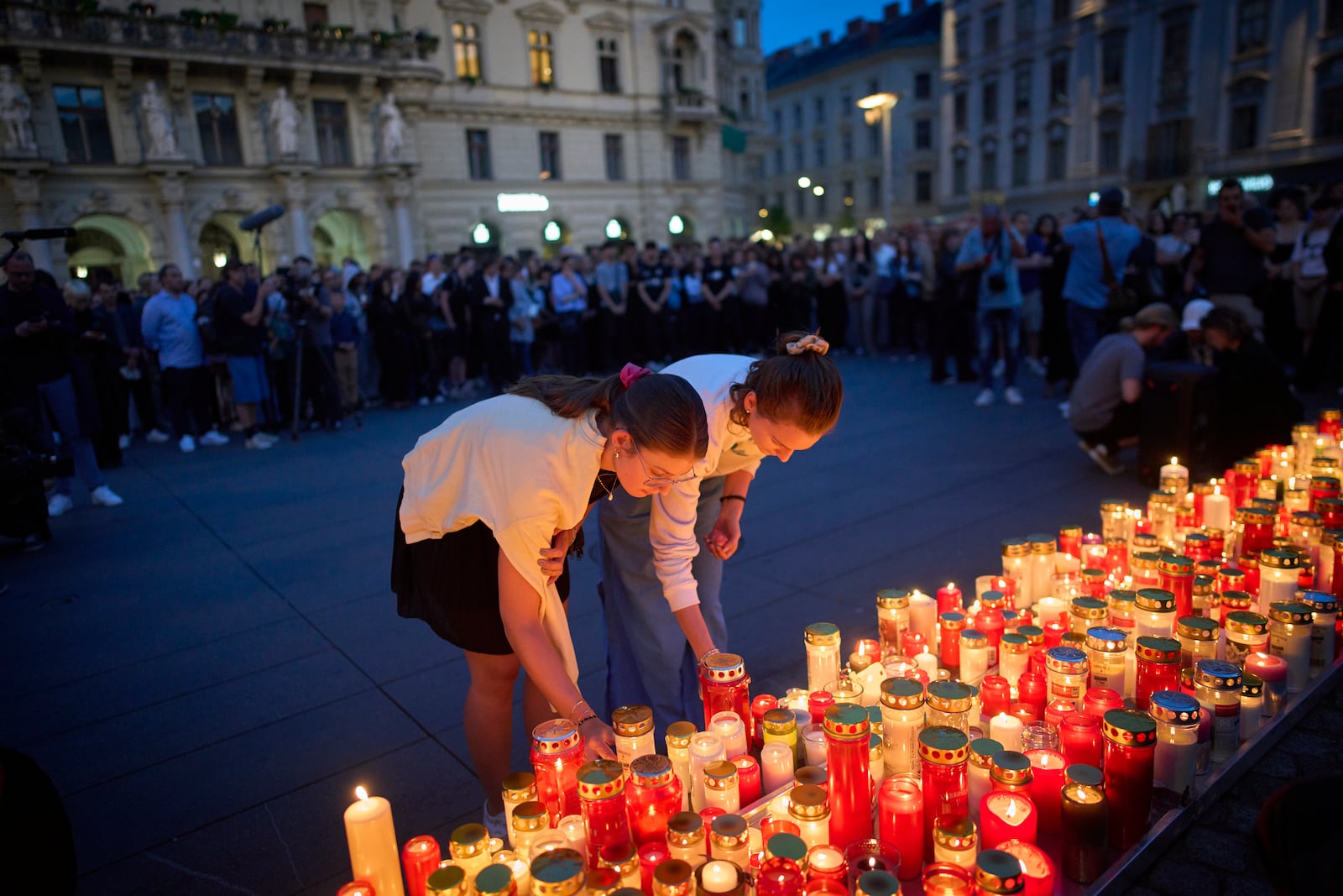 People light candles for victims of a former student who opened fire at a school, fatally wounding 10 people and injuring many others before taking his own life, in Graz, Austria, Tuesday, June 10, 2025. (AP Photo/Darko Bandic)