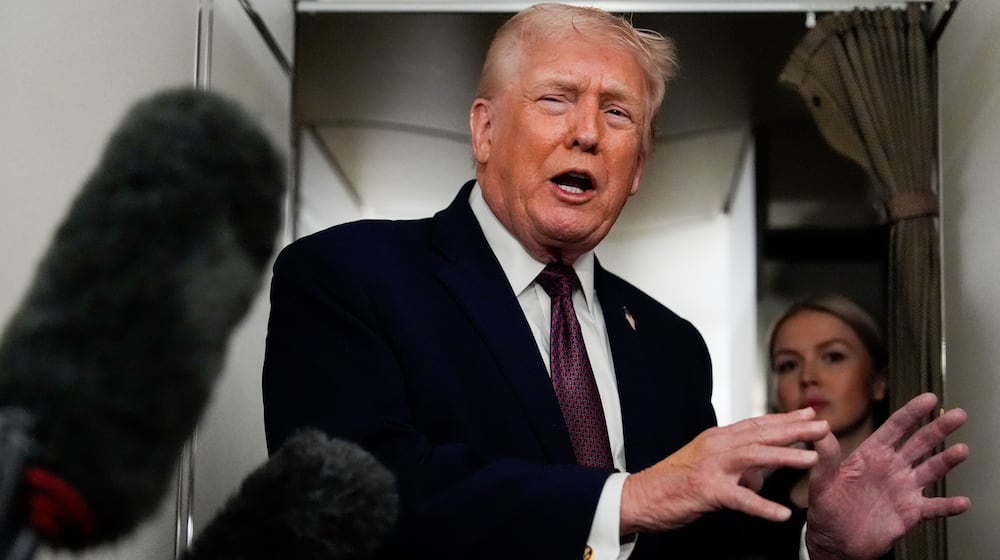 President Donald Trump speaks to reporters while in flight on Air Force One to Joint Base Andrews, Md., Sunday, Jan. 11, 2026. (AP Photo/Julia Demaree Nikhinson)
