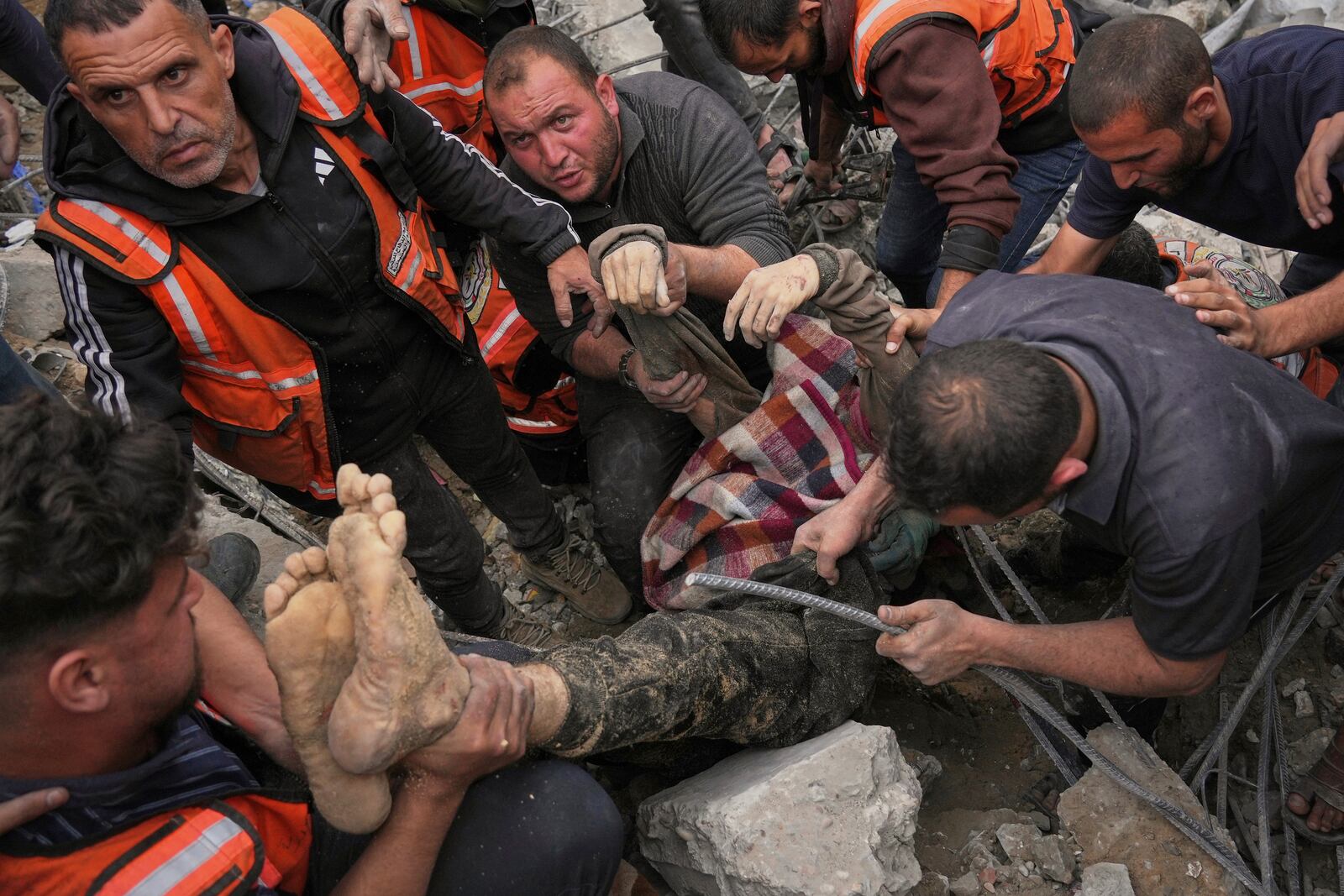A dead man is removed from the rubble of the Manoun family's house after it was targeted by an Israeli army strike in Jabalia al-Balad, Gaza City, Sunday, April 13, 2025. (AP Photo/Jehad Alshrafi)