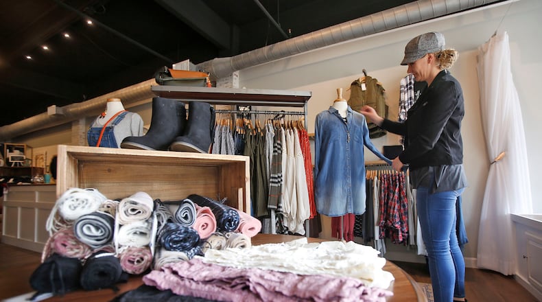 Grace Lane Boutique is one of 32 new business to open in downtown Dayton in 2018. Store owner Danielle Goodman adjusts a mannequin. TY GREENLEES