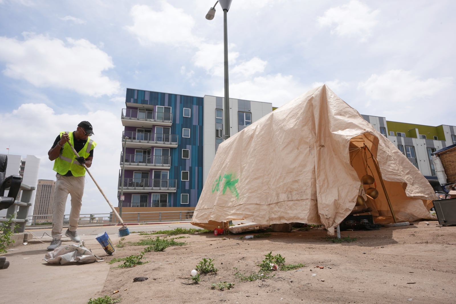 Jay Joshua cleans up around a homeless encampment where he currently lives, Monday, May 12, 2025, in Los Angeles. (AP Photo/Damian Dovarganes)