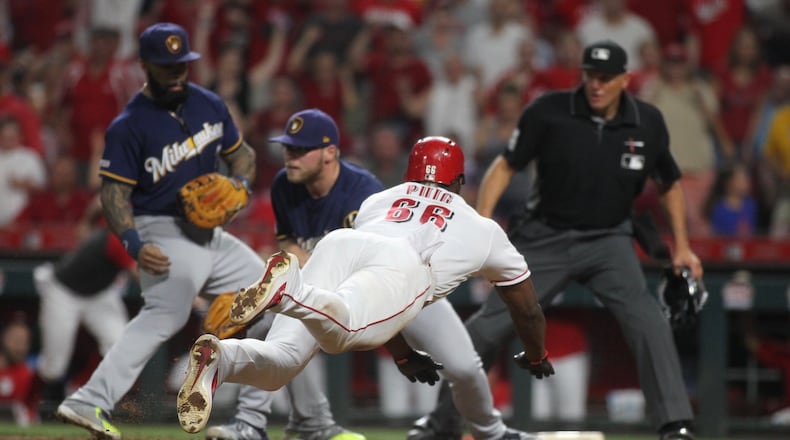 The Reds’ Yasiel Puig scores the winning run against the Brewers on Tuesday, July 2, 2019, at Great American Ball Park in Cincinnati. David Jablonski/Staff