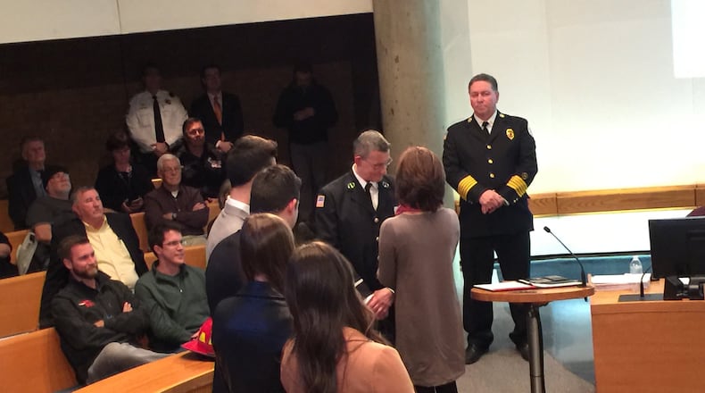 Fire Lt. Pawel Mieczykowski, center, receives his new badge from his wife as his four children, left, and Fire Chief Paul Lolli, right, look on. The pinning ceremony was held during Tuesday’s Middletown City Council meeting. ED RICHTER/STAFF