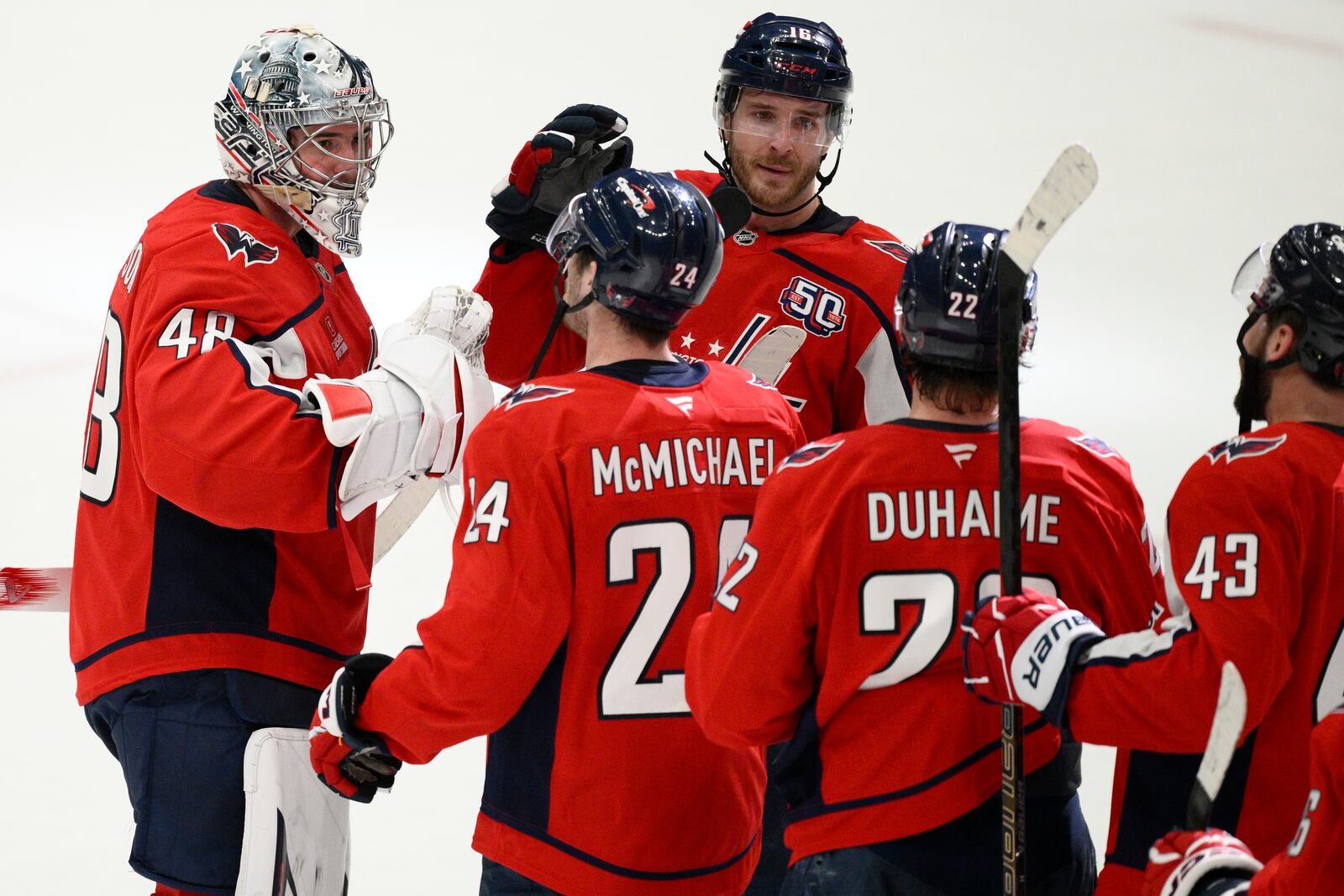 Washington Capitals goaltender Logan Thompson (48) celebrates with center Connor McMichael (24) and others after Game 2 of a first-round NHL hockey playoff series against the Montreal Canadiens Wednesday, April 23, 2025, in Washington. (AP Photo/Nick Wass)