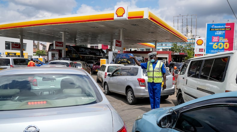 FILE - A policeman directs motorists queueing to buy gasoline at one of the gas stations with fuel still available for sale, in the Hurlingham neighborhood of the capital Nairobi, Kenya, on April 14, 2022. (AP Photo/Khalil Senosi, File)
