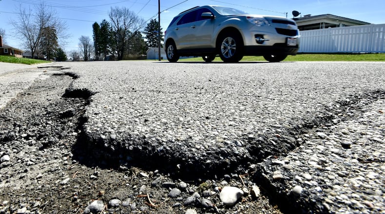 A vehicle travels by a rough patch of W. Roger Drive Wednesday, April 3, 2019 in Trenton. The new 10.5-cent-per-gallon gas tax increase has allowed Trenton to reduce a road levy request from up to 6 mills to 3.9 mills. NICK GRAHAM/STAFF