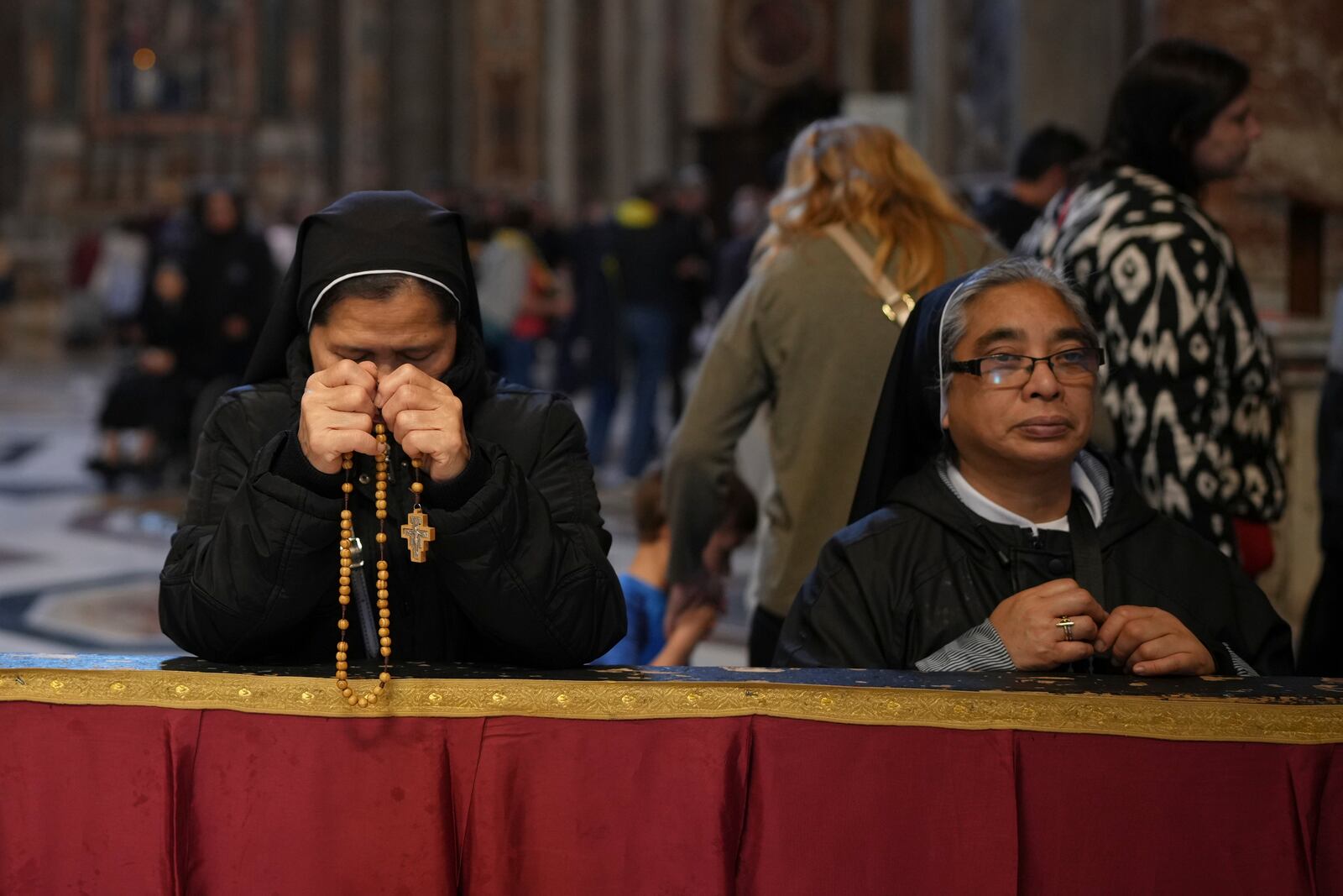 Nuns pray inside St. Peter's Basilica where Pope Francis is lying in state, at the Vatican, Thursday, April 24, 2025. (AP Photo/Alessandra Tarantino)