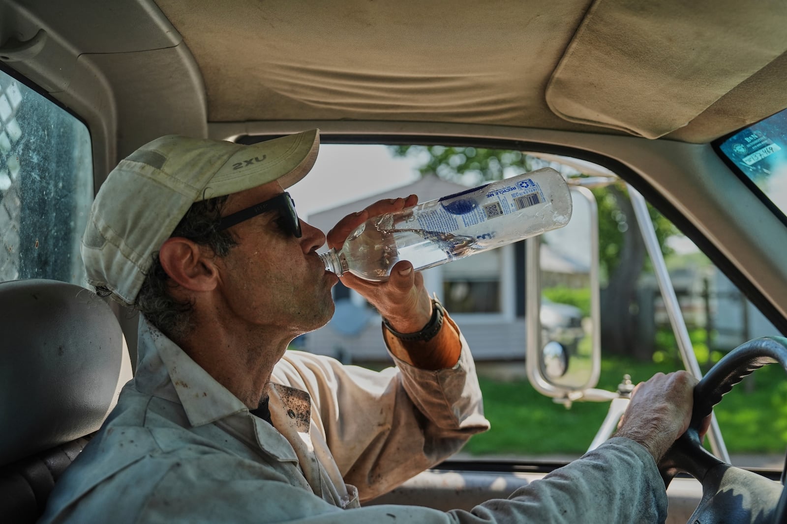 Isaac Barnes takes a drink of water after harvesting honeycomb from his honeybee hives Tuesday, June 24, 2025, in Williamsport, Ohio. (AP Photo/Joshua A. Bickel)