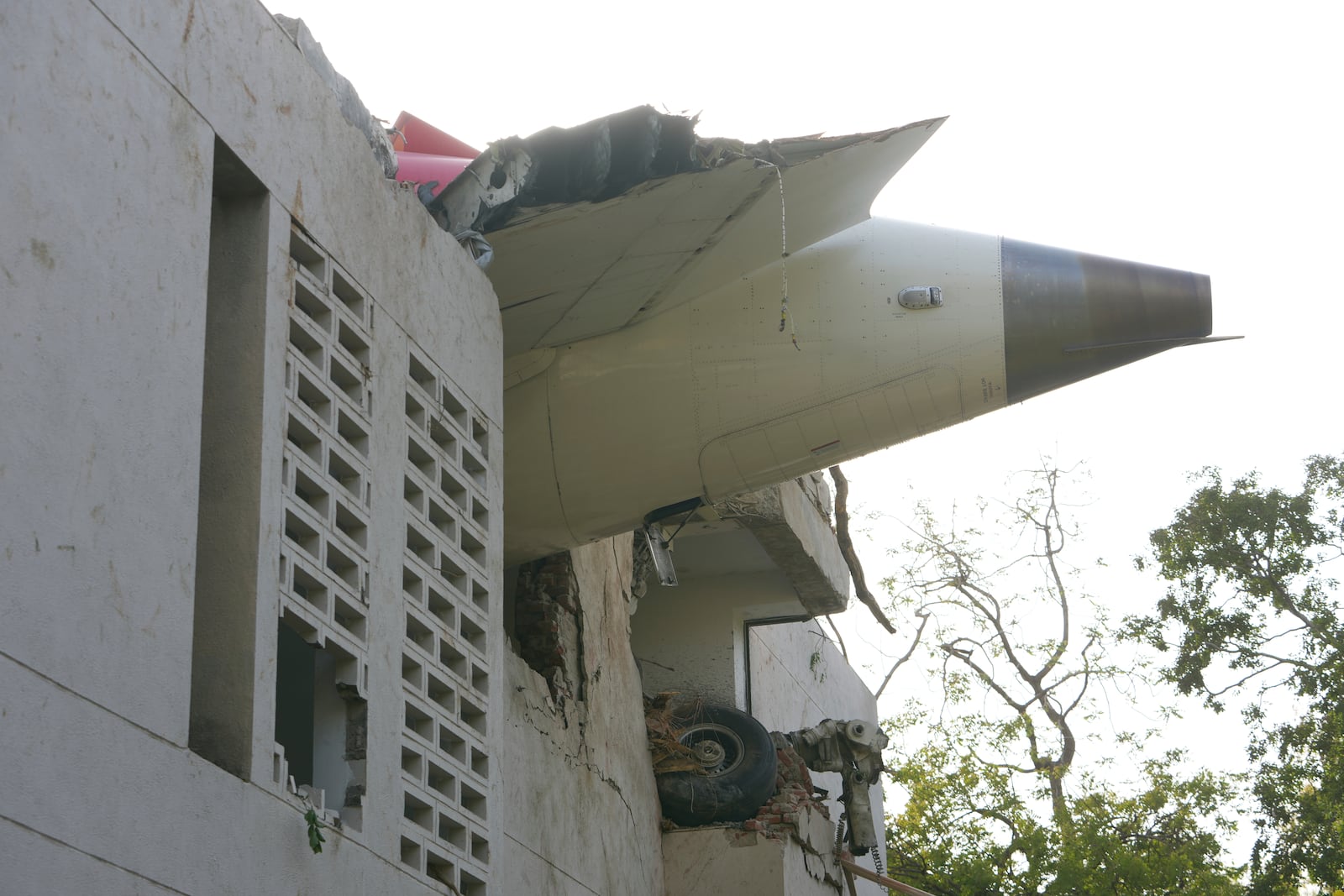 The debris of an airplane sticks out of a building after it crashed in India's northwestern city of Ahmedabad in Gujarat state, Thursday, June 12, 2025. (AP Photo/Ajit Solanki)
