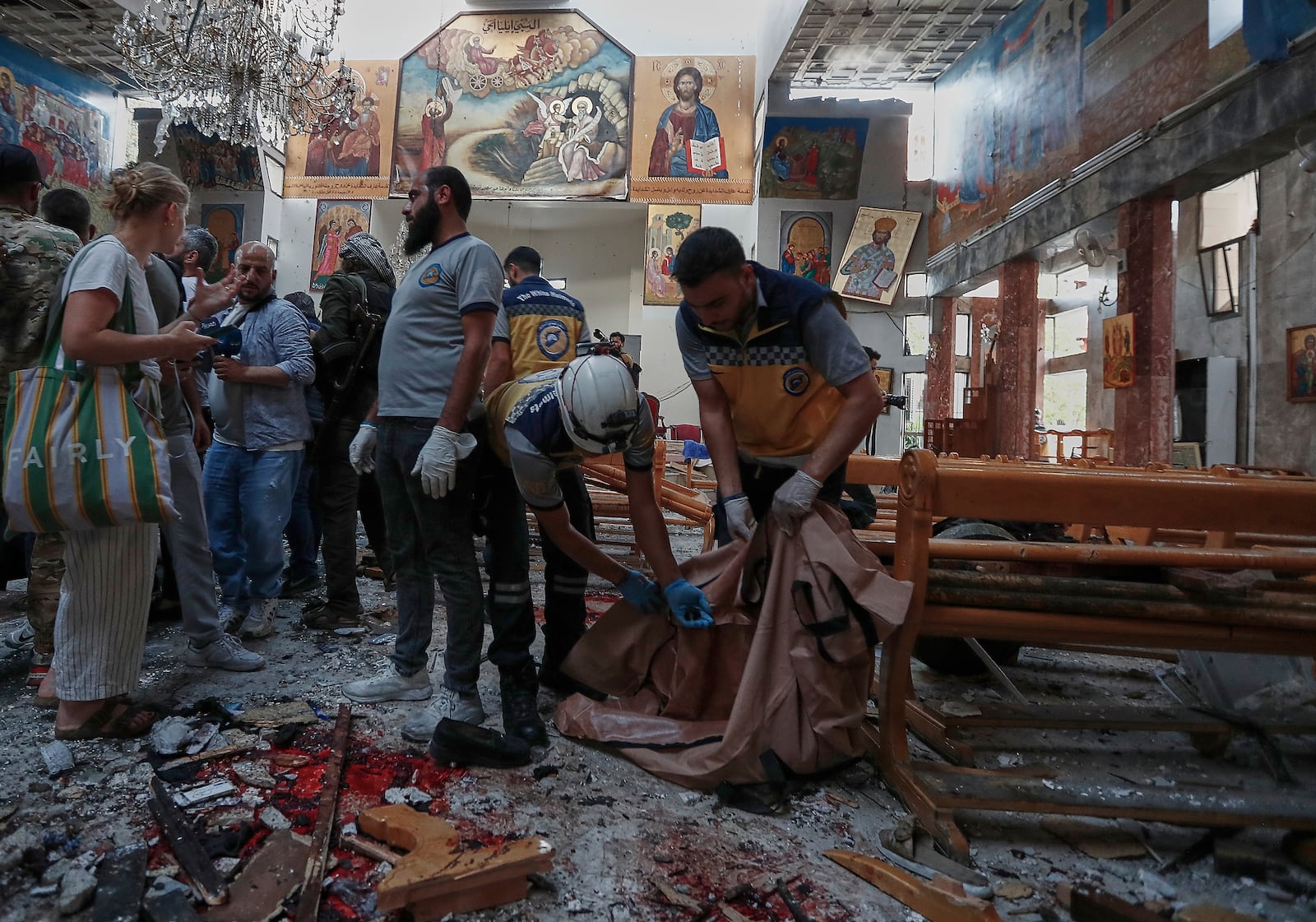 Syrian Civil Defence workers remove body remains inside Mar Elias church where a suicide bomber detonated himself in Dweil'a in the outskirts of Damascus, Syria, Sunday June 22, 2025. (AP Photo/Omar Sanadiki)