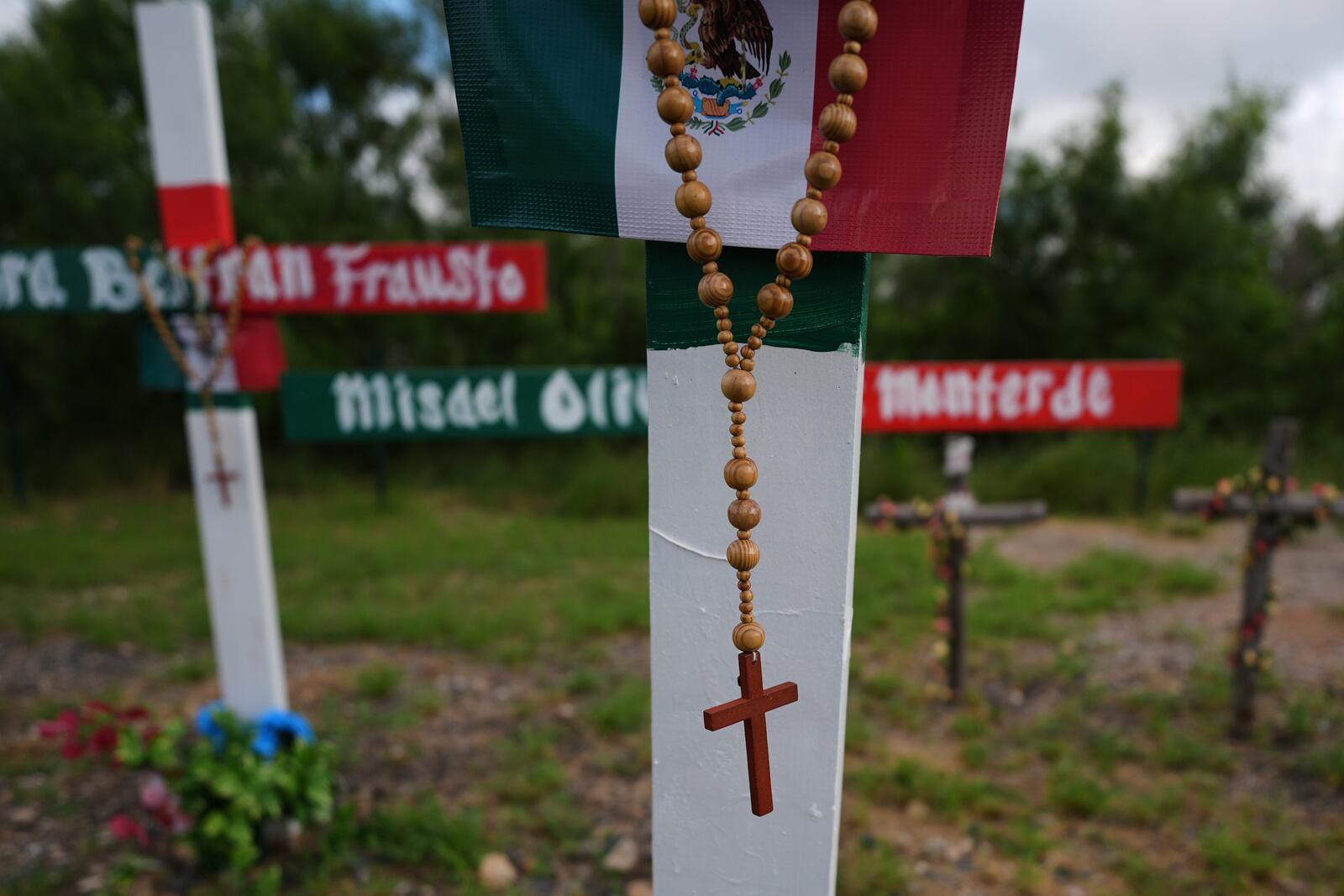 Crosses stand at a memorial honoring the victims and survivors of a human smuggling tragedy where dozens of migrants were found in an airless tractor-trailer rig two years ago, in San Antonio, Friday, June 27, 2025. (AP Photo/Eric Gay)