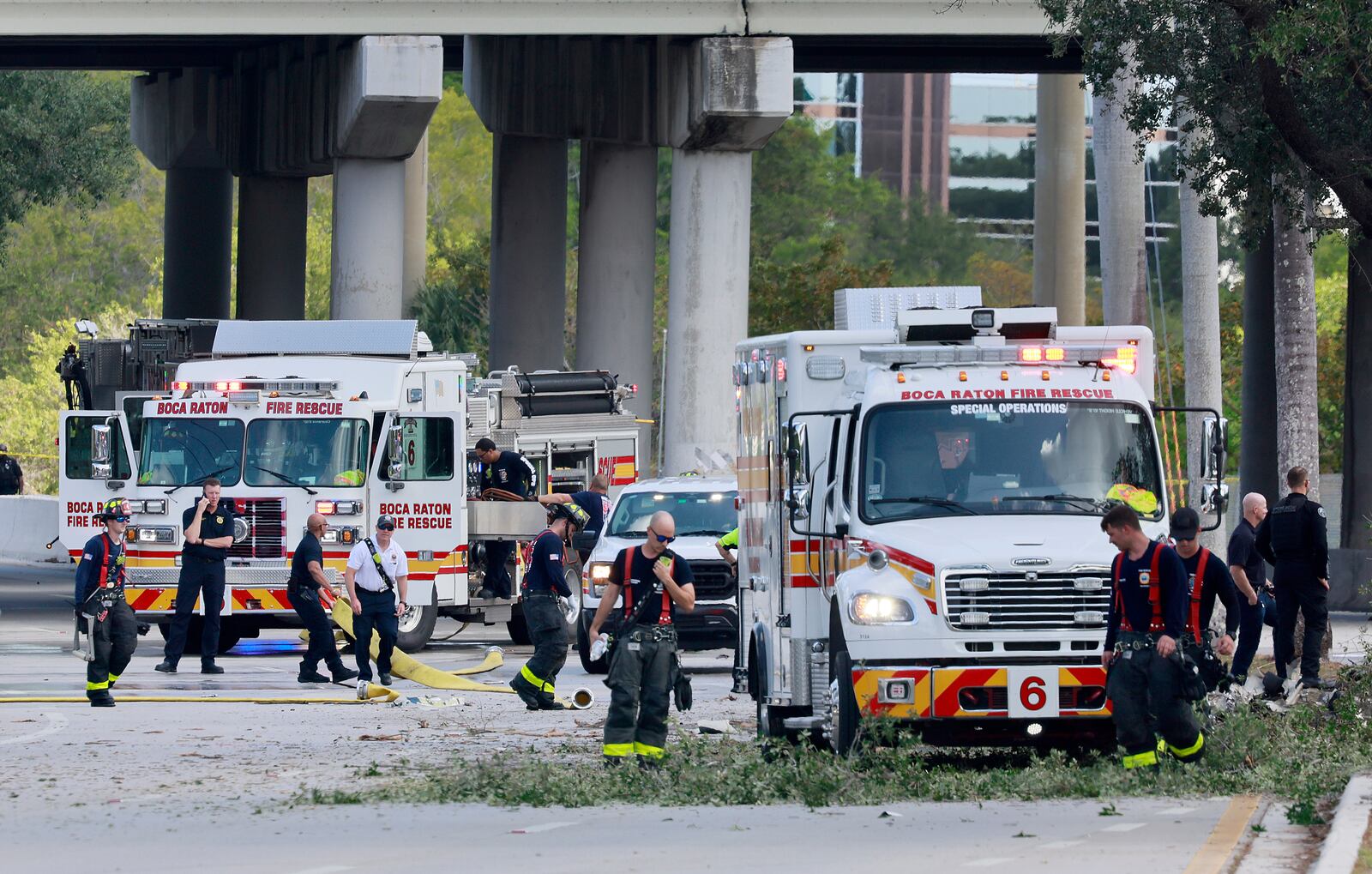 Emergency personnel respond to the area where a small plane crashed on the railroad tracks beneath the overpass near Interstate 95 in Boca Raton, Fla., on Friday, April 11, 2025. (Mike Stocker /South Florida Sun-Sentinel via AP)