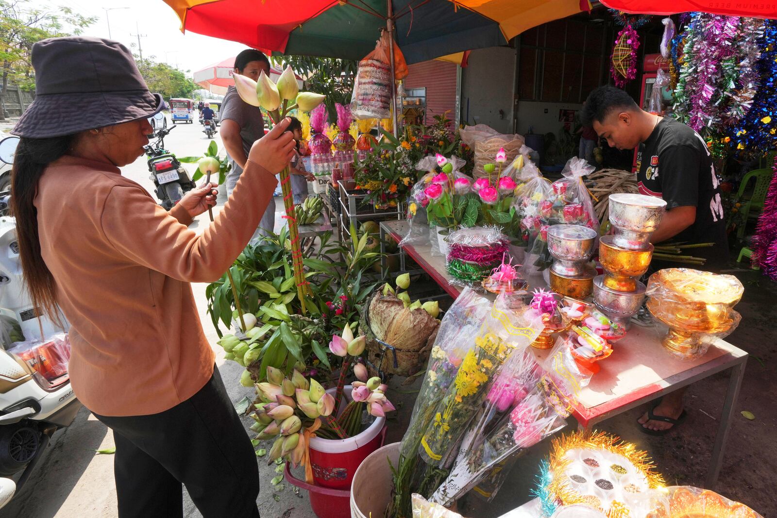 Villagers buy flowers to celebrate the traditional New Year holiday at the outskirts of Phnom Penh Cambodia, Sunday, April 13. 2025. People celebrate the traditional New Year holiday between April 14-16. (AP Photo/Heng Sinith)