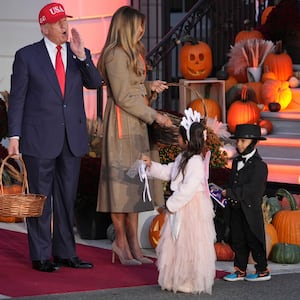 President Donald Trump, from left, and first lady Melania Trump hand candy to children dressed the Tooth Fairy and Abraham Lincoln during a Halloween event on the South Lawn of the White House, Thursday, Oct. 30, 2025, in Washington. (AP Photo/Jacquelyn Martin)