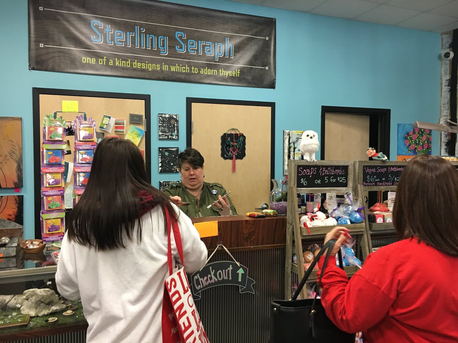 Sterling Seraph, a Fairfield Twp. artisan store featuring sterling silver jewelry made with rock, crystal, fossil and gemstones, had steady stream of customers on Black Friday as owner Dawn Singleton handles transactions at the cash register. WAYNE BAKER/STAFF