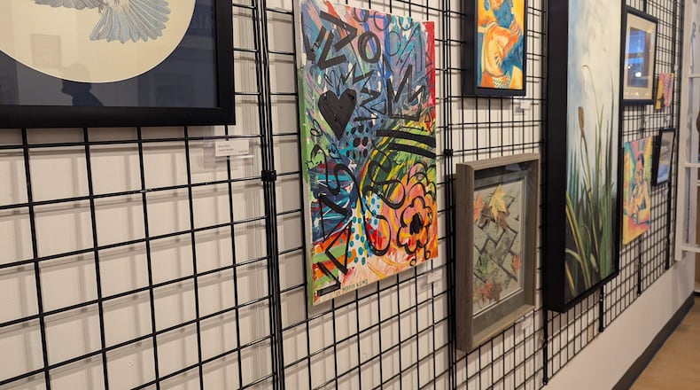Colorful artwork by Marie Kline hangs among other pieces in the "Created to Create" exhibit at The Strauss Gallery in downtown Hamilton. CONTRIBUTED