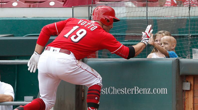 Reds first baseman Joey Votto high fives six-year old Walter Herbert (right) after hitting a solo home run.