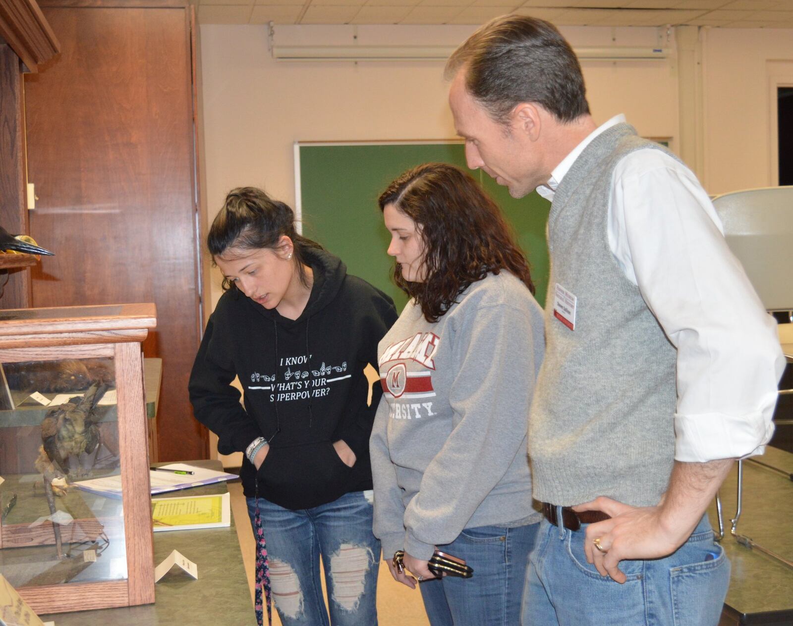 Sisters Brooke Sullivan, from left, and Paige Sullivan, both students at the Miami University Hamilton campus, talk with Hefner Museum director Steve Sullivan about passenger pigeons.