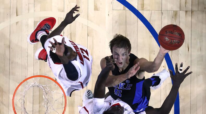NEW YORK, NY - MARCH 09: Luke Kennard #5 of the Duke Blue Devils shoots against Deng Adel #22 and Mangok Mathiang #12 of the Louisville Cardinals during the Quarterfinals of the ACC Basketball Tournament at the Barclays Center on March 9, 2017 in New York City. (Photo by Al Bello/Getty Images)