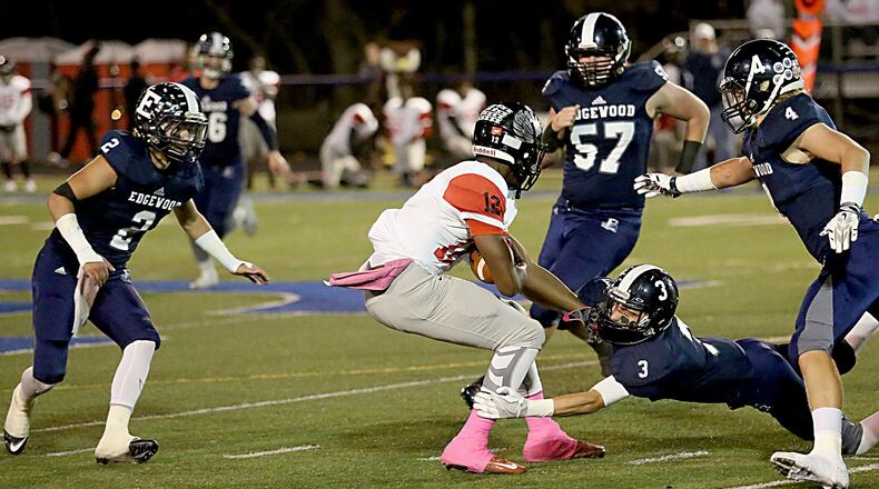 Edgewood defensive back Nick Noble hangs on to Mt. Healthy’s Tyree Roberson as EHS teammates D.J. Whiles (2), Greg Dingledine (57) and (4) Evan Brown come in to assist during their game in Trenton on Oct. 28, 2016. Edgewood won 49-28. CONTRIBUTED PHOTO BY E.L. HUBBARD