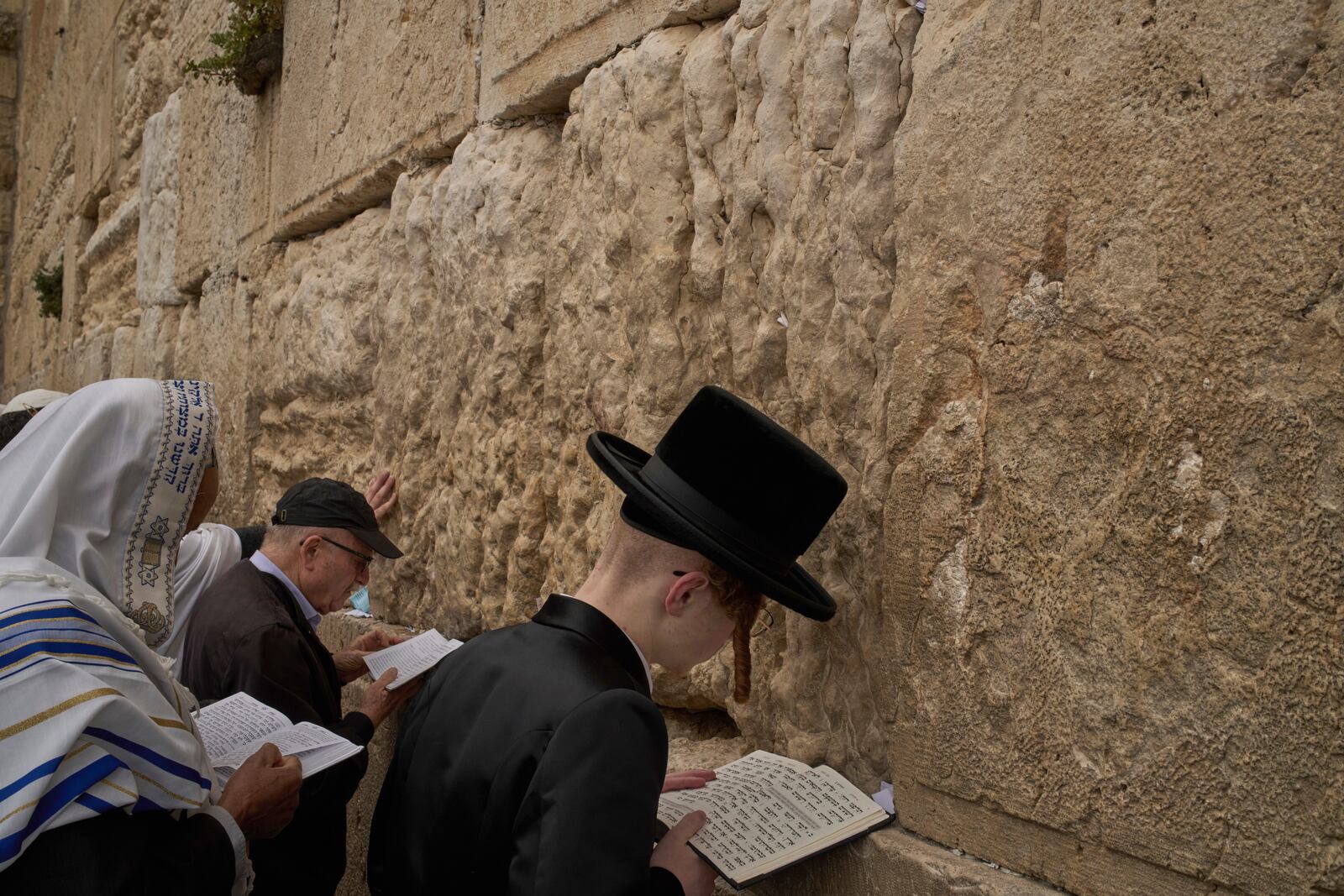 An ultra-Orthodox Jewish young man prays as he participates in a blessing during the holiday of Passover, at the Western Wall, the holiest site where Jews can pray, in the Old City of Jerusalem, Tuesday, April 15, 2025. (AP Photo/Leo Correa)