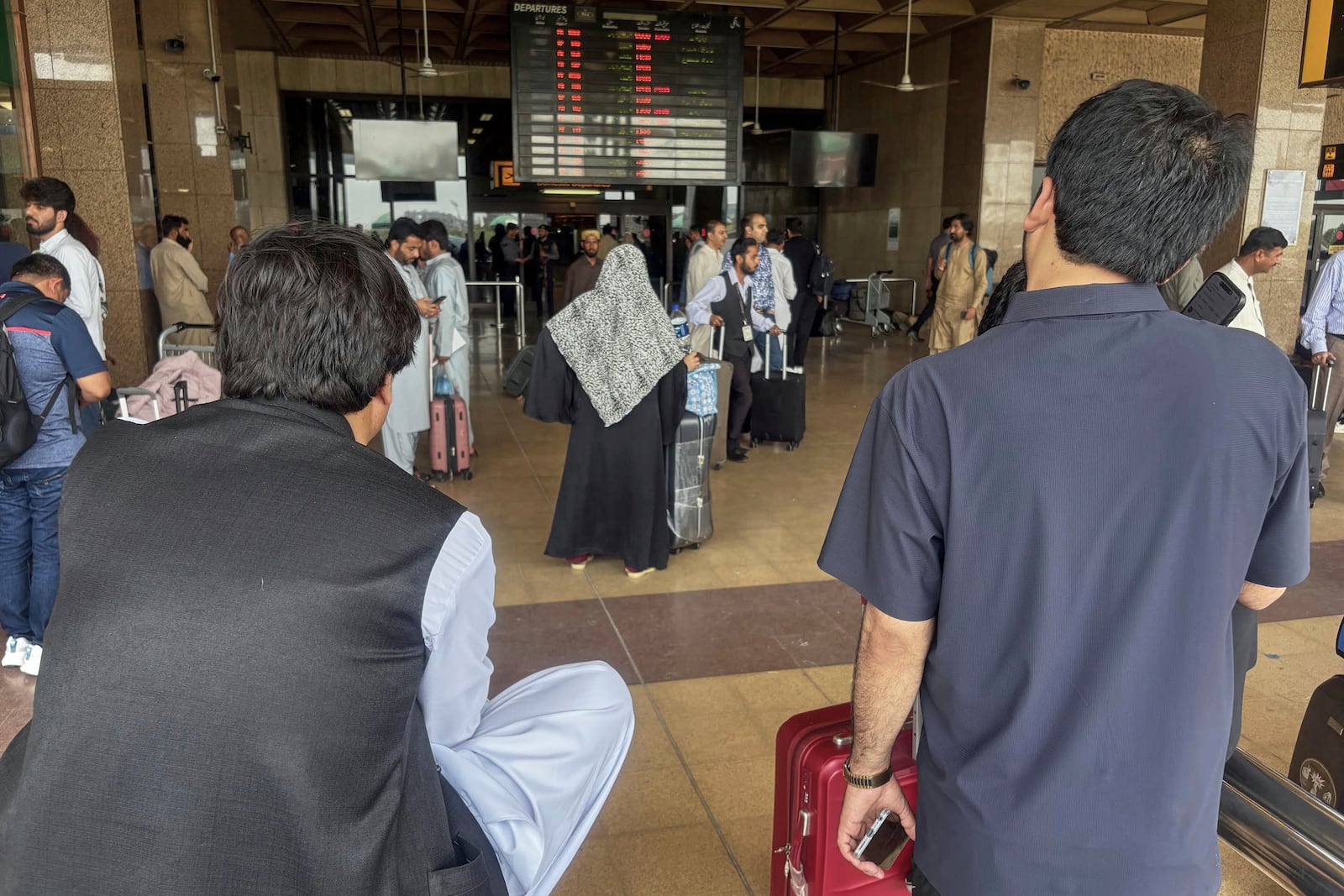 Stranded passengers wait at an arrival area of Jinnah airport after authorities closed the airport due to India's drone attack to Pakistan, in Karachi, Pakistan, Thursday, May 8, 2025. (AP Photo/Mohammad Farooq)