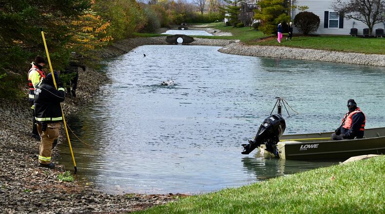 Rescue workers searched a pond Thursday at a West Chester Twp. apartment complex for a missing 7-year-old boy with a boat drone. MICHAEL D. PITMAN/STAFF