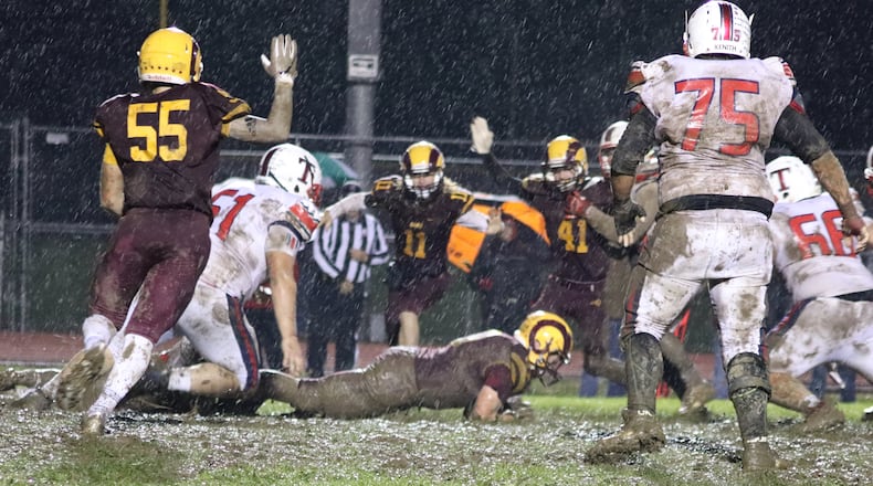 Andrew Redemeier of Ross recovers a fumble as he’s surrounded by teammates Jack DePrie (55), Jordan Hodge (11) and Will Palmer (41) during Friday night’s game against visiting Talawanda at Robinson Field in Ross Township. On the play for the Braves are Ryan McGuire (61) and Andrew Marcum (75). Ross won 18-7. CONTRIBUTED PHOTO BY KAREN REDEMEIER