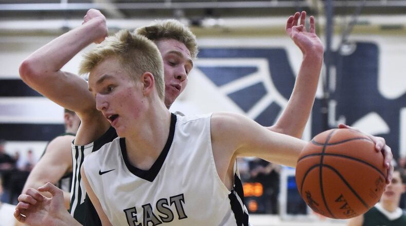 Lakota East’s Adam Dieball dribbles under the basket while being guarded by Mason’s Matt King on Feb. 20, 2015, at East. NICK GRAHAM/STAFF