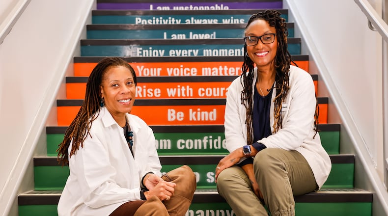 Verlena Stewart, left, former CBI executive director, and Marie Edwards, new CBI executive director, sit on steps in the new expansion of Robert "Sonny" Hill Jr. Community Center in Middletown. NICK GRAHAM/STAFF