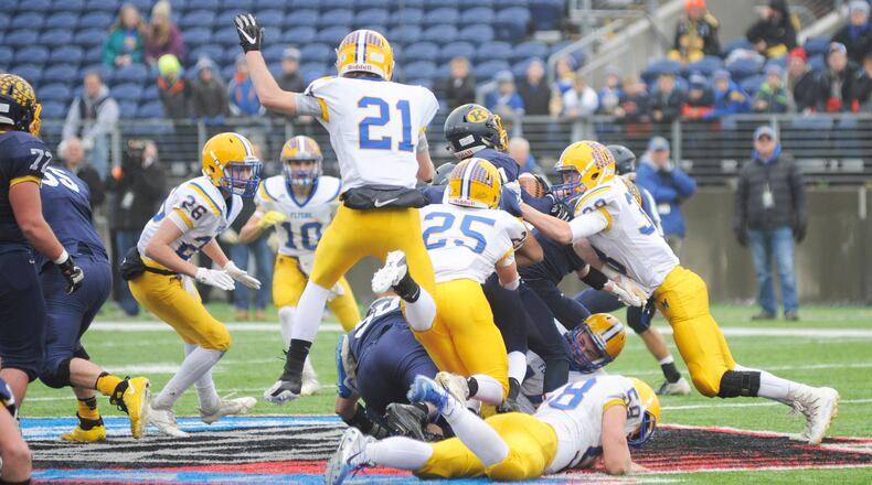 Marion Local’s Dylan Heitkamp (21), Brandon Fleck (25), Tanner Ungruhn (38) and Matt Everman (bottom) get defensive. Kirtland defeated Marion Local 16-7 in the D-VI high school football state championship at Canton’s Tom Benson Hall of Fame Stadium on Friday, Nov. 30, 2018. MARC PENDLETON / STAFF