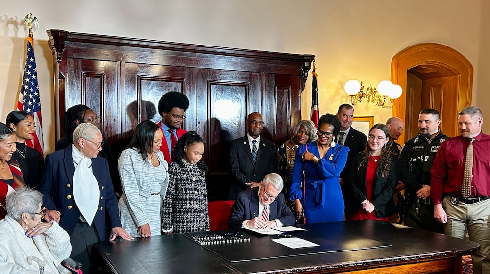 Avery and Drew Russell stand to the right of Ohio Gov. Mike DeWine as he signs House Bill 247 on December 19, 2025. Avery Russell, 12, was the victim of a vicious pit bull attack in June 2024. CONTRIBUTED