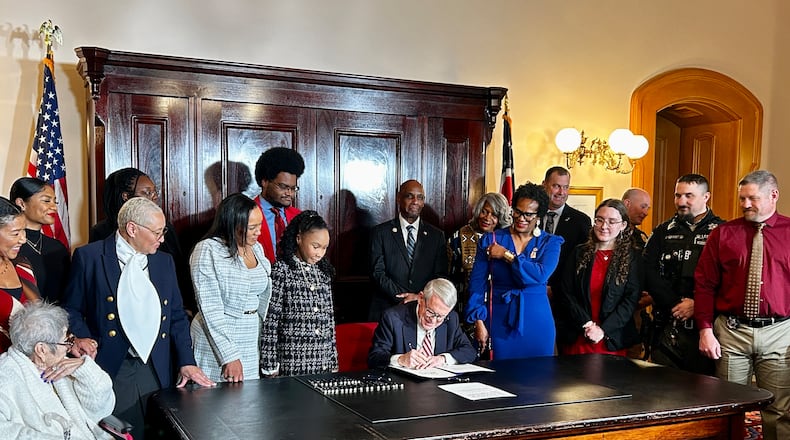Avery and Drew Russell stand to the right of Ohio Gov. Mike DeWine as he signs House Bill 247 on December 19, 2025. Avery Russell, 12, was the victim of a vicious pit bull attack in June 2024. CONTRIBUTED