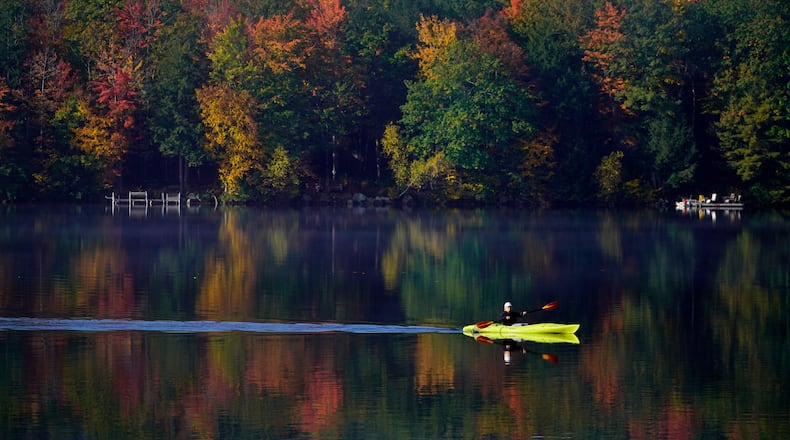 FILE - Virginia Davidson of Bridgton, Maine, paddles her kayak on Moose Pond, Oct. 13, 2021, in Bridgton, Maine. (AP Photo/Robert F. Bukaty)