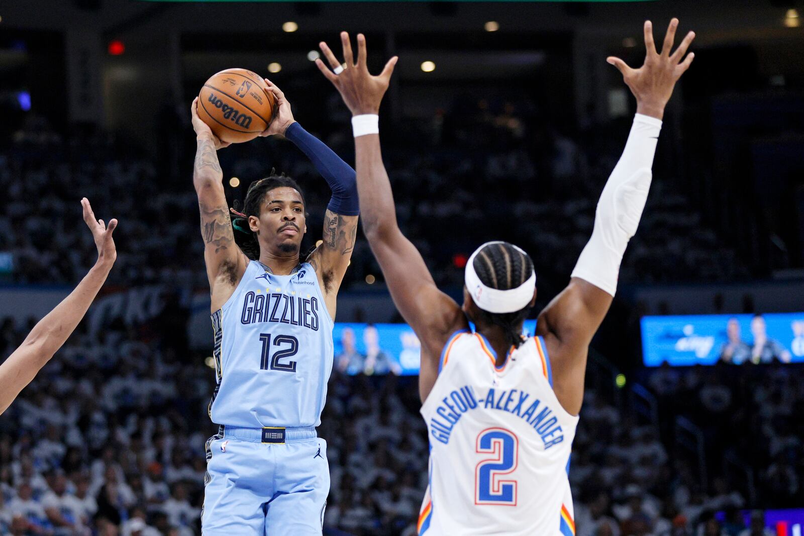 Memphis Grizzlies guard Ja Morant (12) looks to pass the ball away from Oklahoma City Thunder guard Shai Gilgeous-Alexander (2) during the second half in Game 1 of an NBA first-round playoff series, Sunday, April 20, 2025, in Oklahoma City. (AP Photo/Nate Billings)