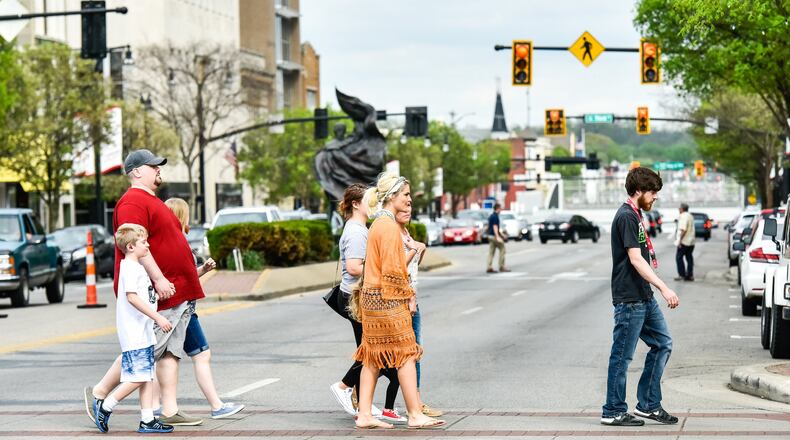 Pedestrians cross High Street May 3 during the Alive After 5 event in downtown Hamilton. NICK GRAHAM/STAFF