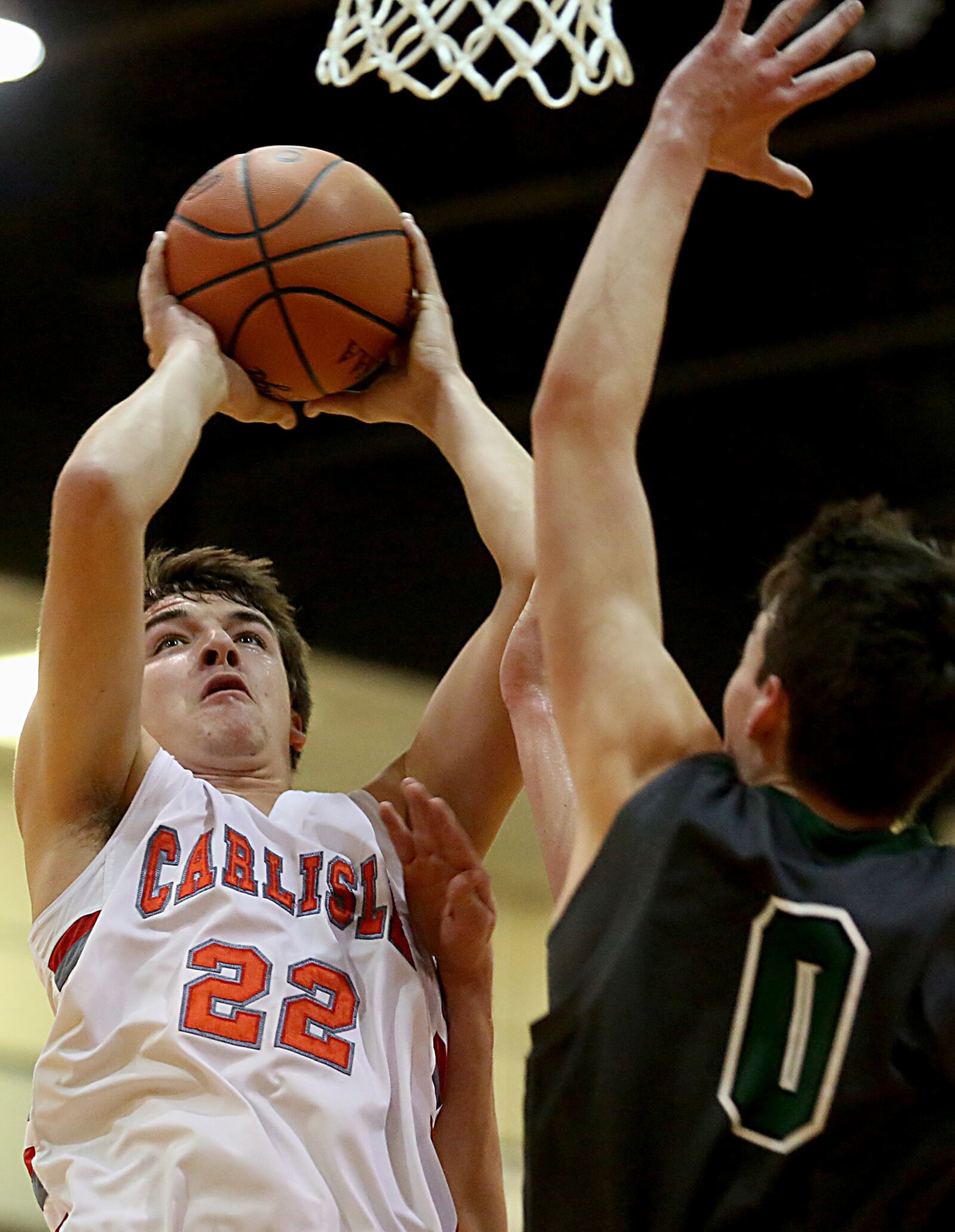 Carlisle forward Justin Flor is defended by Badin center Jakob Tipton on Saturday night at The Pit in Carlisle. CONTRIBUTED PHOTO BY E.L. HUBBARD