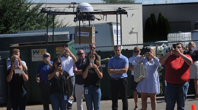 Winsupply employees watch the company's inaugural drone delivery flight arrive at the Centerville Winsupply in Washington Twp. from the Winsupply Distribution Center in Miami Twp. Friday, Aug. 12, 2022. MARSHALL GORBY/STAFF