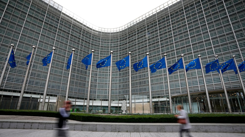 FILE - European Union flags flap in the wind as pedestrians walk by EU headquarters in Brussels, Wednesday, Sept. 20, 2023. (AP Photo/Virginia Mayo, File)