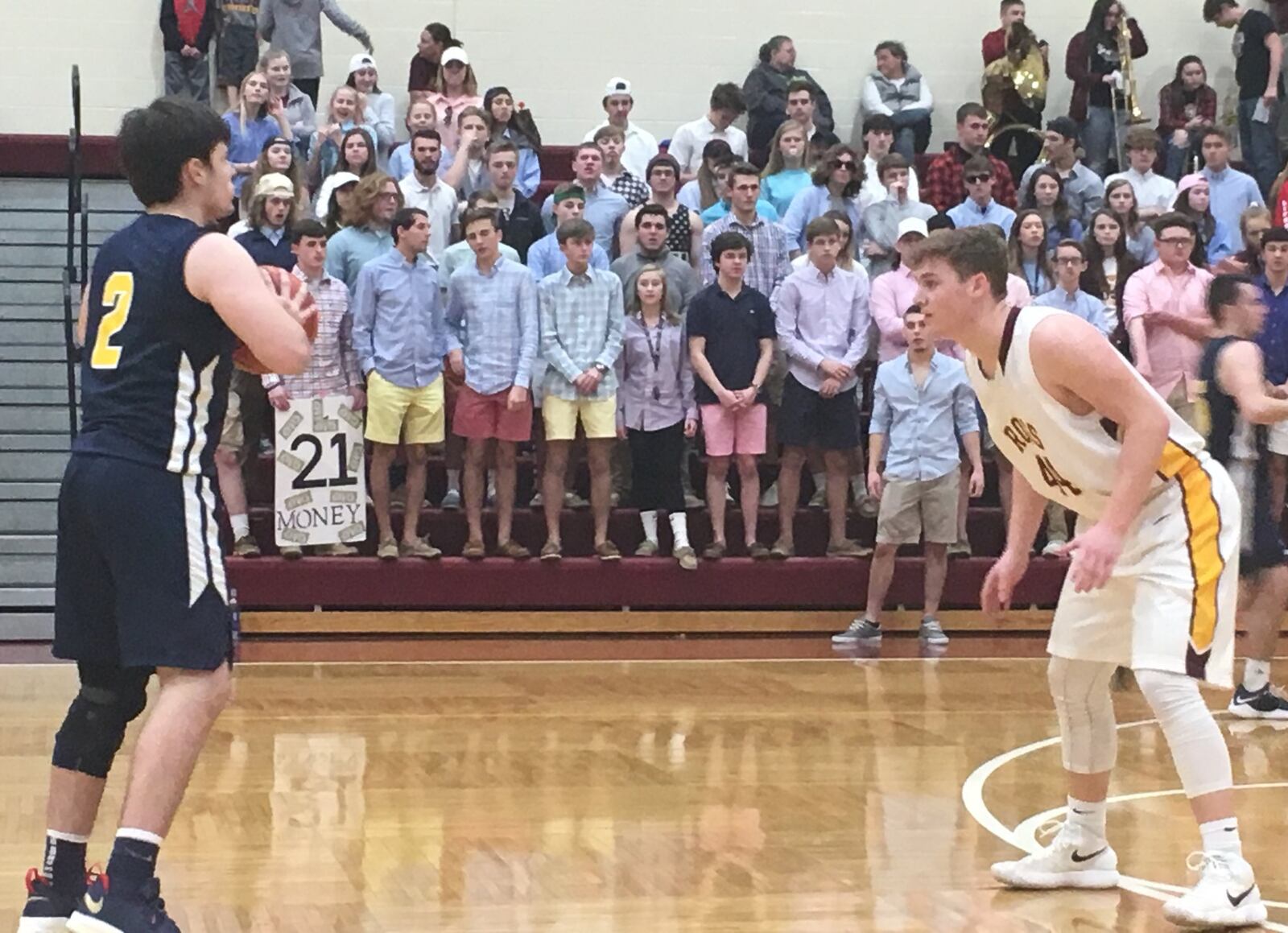 Joe Valentine (44) of Ross has Monroe’s Nick Osterman (2) firmly in his sights as the Ross student section watches Tuesday night at RHS. RICK CASSANO/STAFF