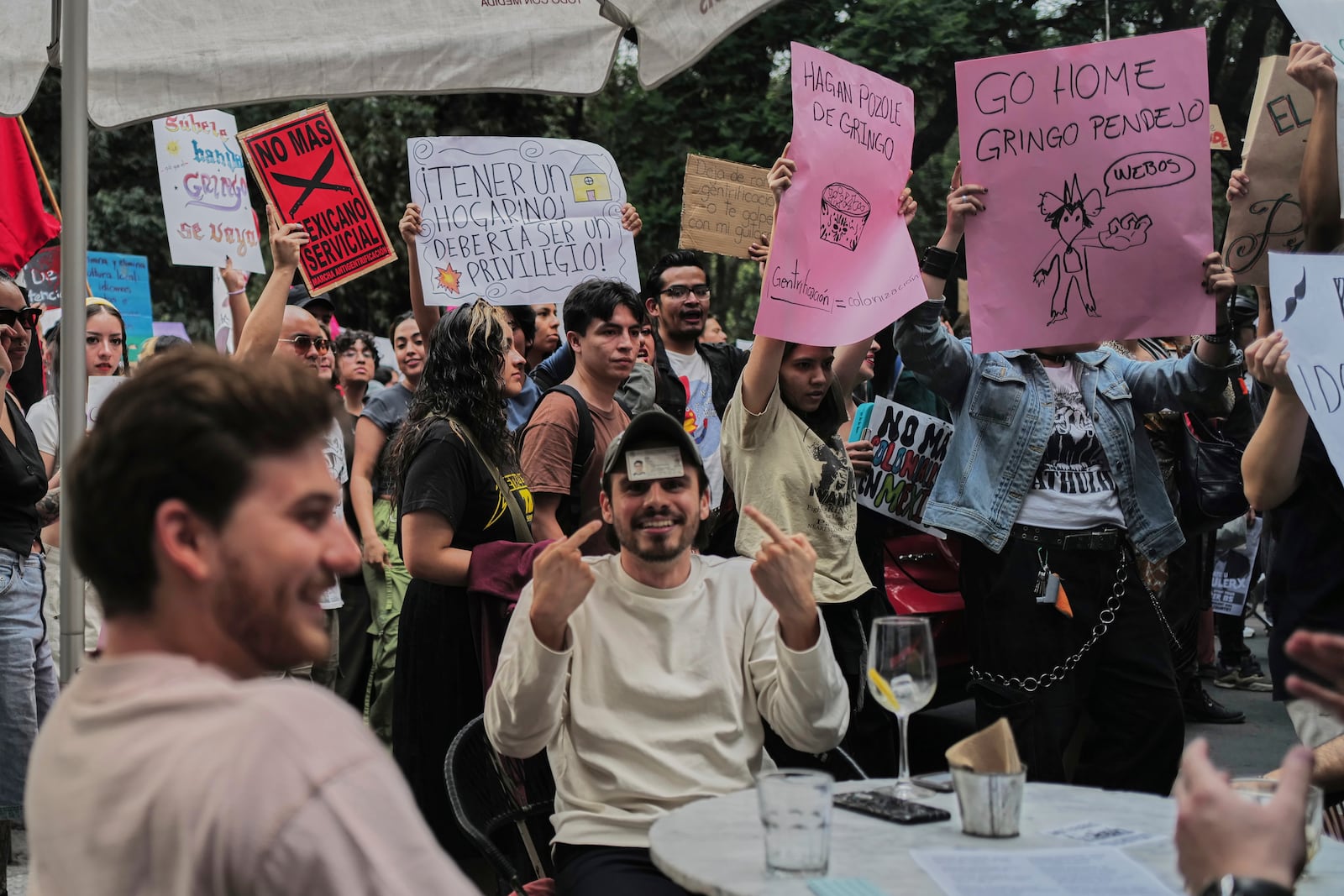 A man points to his Mexican ID to prove his nationality as people protest against gentrification, as the increase in remote workers has risen prices and increased housing demand in neighborhoods like Condesa and Roma, in Mexico City, Friday, July 4, 2025. (AP Photo/Jon Orbach)