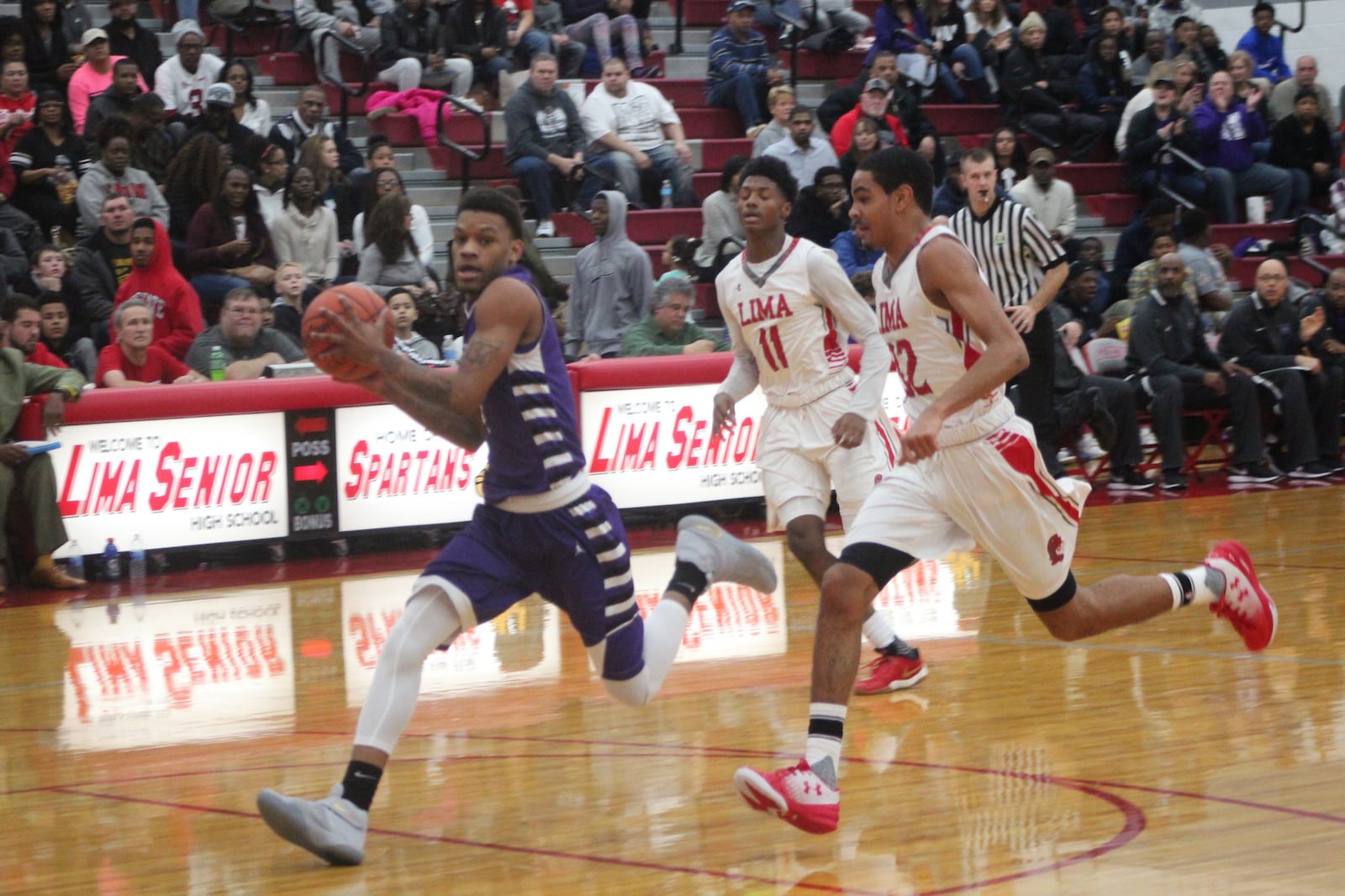 Middletown’s Nelson Rutledge drives past Lima Senior’s Jaleel King (11) and Marquis Coleman (32) during Friday night’s game in Lima. CONTRIBUTED PHOTO BY MARITZA MCKINNEY