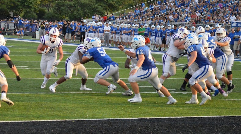 Middletown’s Gene Underhill (21) carries the ball as he’s pursued by Springboro defenders Calvin Walters (34), Jake Kowalski (54), Cameron Snurr (42) and Lincoln Troxell (40) last Friday night at CareFlight Field in Springboro. CONTRIBUTED PHOTO BY ERIC FRANTZ