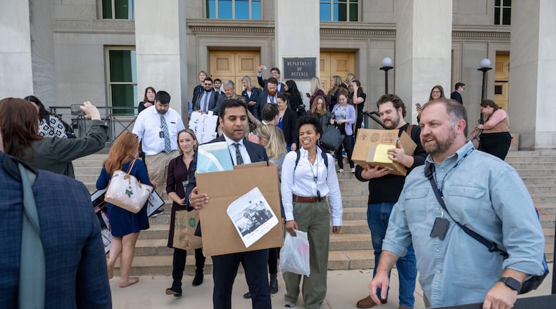 Members of the Pentagon press corp carry their belongings out of the Pentagon after turning in their press credentials, Wednesday, Oct. 15, 2025 in Washington. (AP Photo/Kevin Wolf)