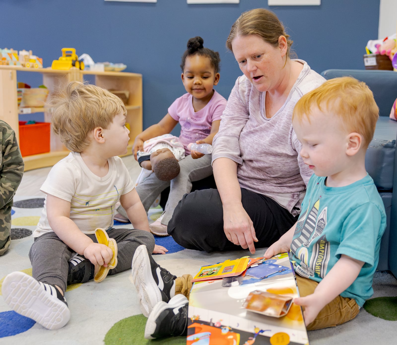 ashley Boyce (top right) watches children at Mini University on Tuesday, March 10 at Sinclair Community College. A Dayton Daily News investigation found many families are struggling to fund childcare, which can cost hundreds to thousands of dollars per month. BRYANT BILLING / STAFF