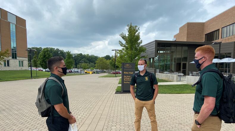 Wright State University students Caleb Matos, a junior in psychology; Philip Bertsch, a junior majoring in political science; and William Bayham, a mechanical engineering major have a conversation on campus Thursday afternoon. The friends, who are all ROTC cadets, said the university has done a great job of putting place safety measures to limit the spread of COVID-19.