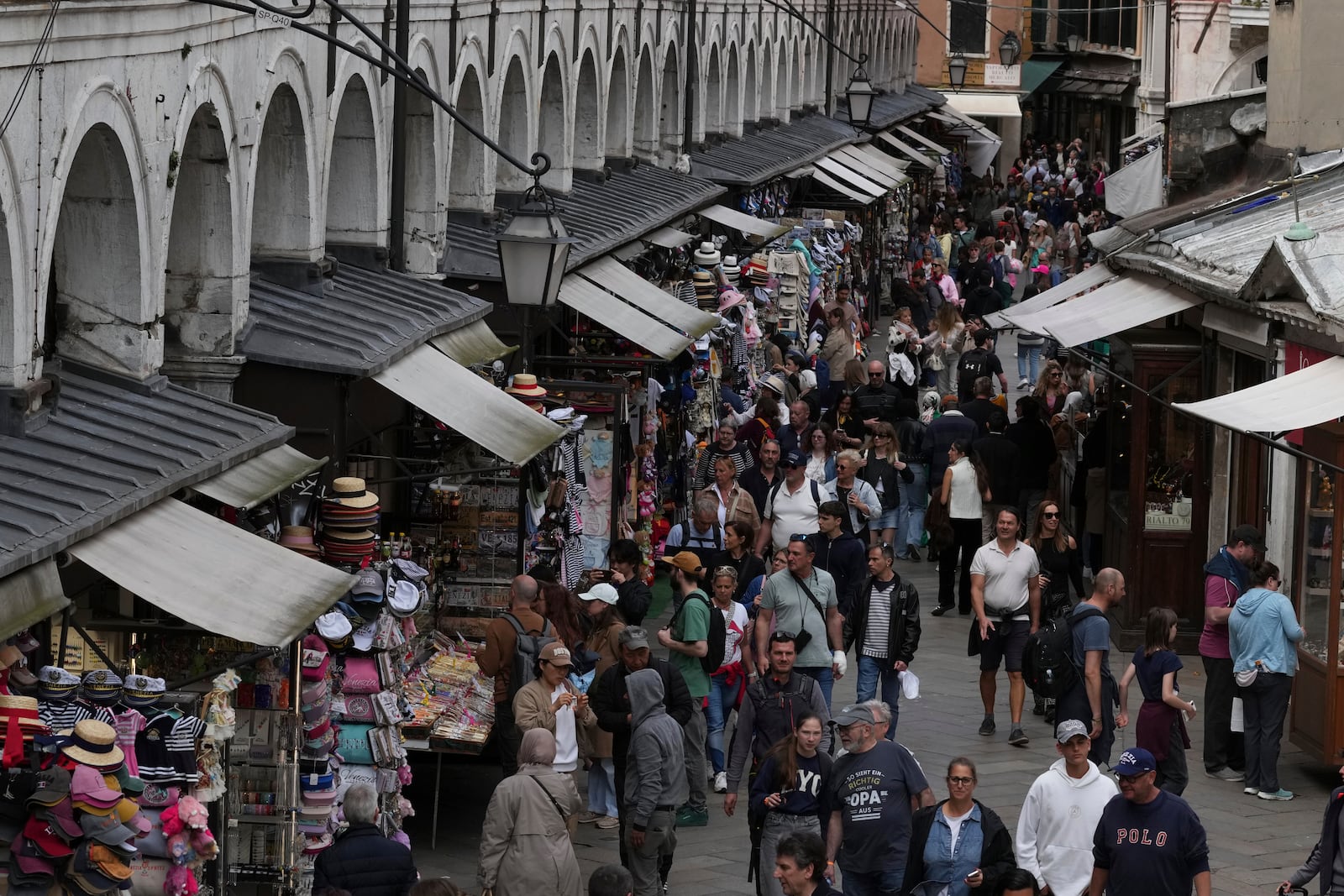 Tourists walk in Venice, Italy, Friday, April 18, 2025, Venice on Friday launches for a second year a pilot program to charge day-trippers an entrance fee. (AP Photo/Antonio Calanni)