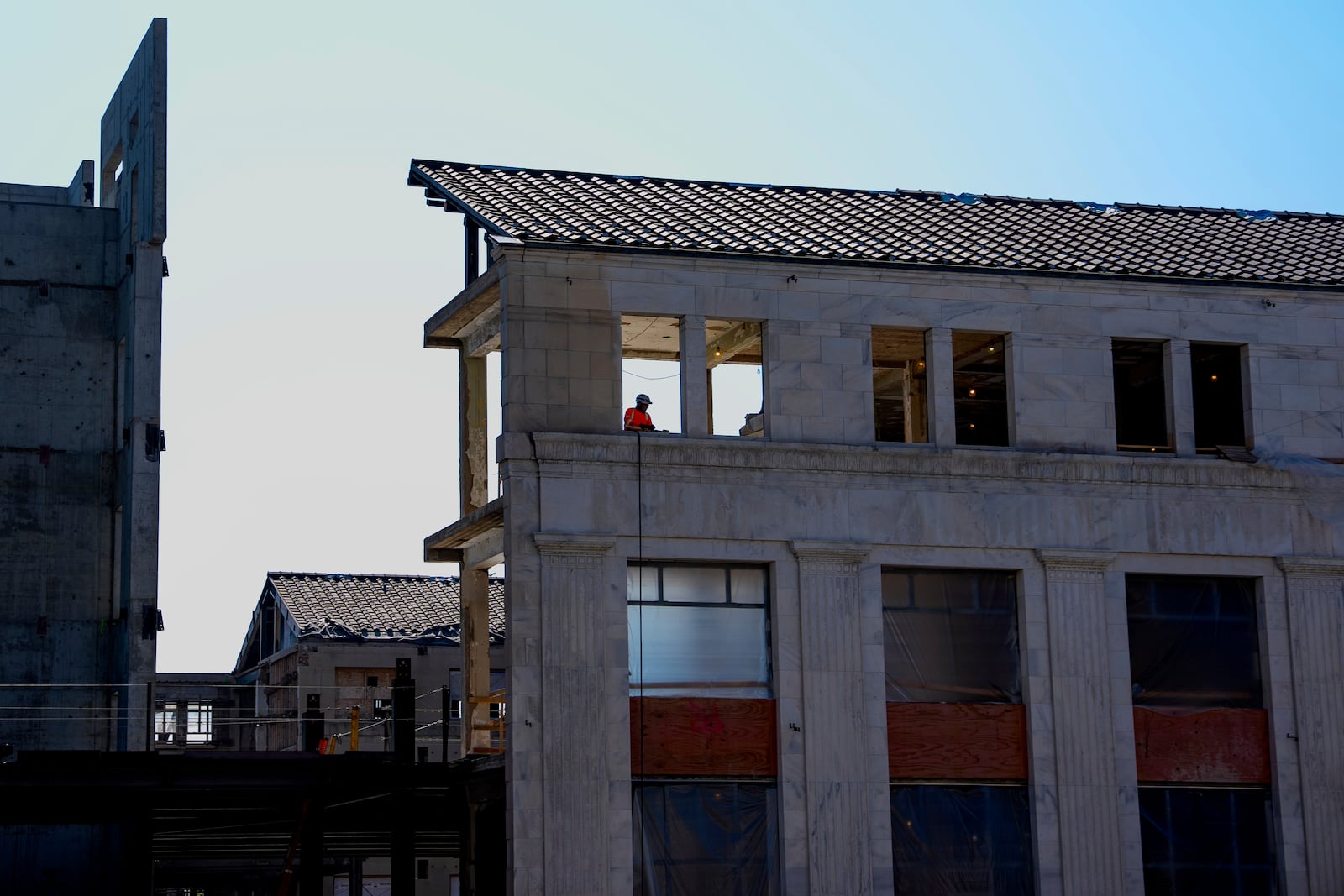 A worker is visible in the window of the 1951 Constitution Avenue Building as a renovations continue on the Federal Reserve, Thursday, July 24, 2025, in Washington. (Andrew Harnik/Pool Photo via AP)
